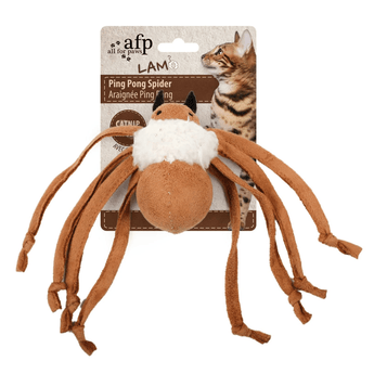 Brown spider toy with a white wool body backed onto packaging with a tabby cat pictured on it, all on a white background.