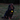 A long-haired black and tan dog sitting on grass at dusk, wearing a red collar with an Ancol glowing yellow acorn-shaped pet lantern attached to the collar.