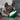 French bulldog type dog laying is head on a mini green Ancol Made From Turtle dog toy, pictured on a grey wooden floor.