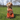 A light brown poodle cross breed dog with an Ancol Orangutan dog toy sat in front of it, pictured on grass.