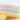 White background with a close up of a small animal Ancol yellow slicker brush with white tipped metal bristles.