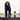 Black cocker spaniel dog dripping wet, stood on a tiled area, next to a black and yellow bottle of Animology Fox Poo Dog Shampoo.