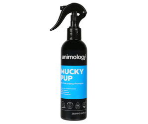 White background with a black and blue spray bottle of Animology Mucky Pup Shampoo. On the bottle is white text 'Animology Mucky Pup, No rinse puppy shampoo'.