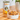 Calibra dog food can and bowl of dog food on a wooden table with a plant in the background.
