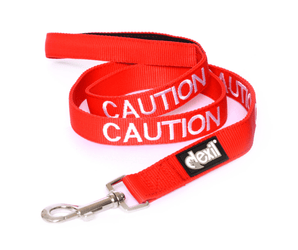 White background with a red Dexil lead with the word 'caution' stitched in white.