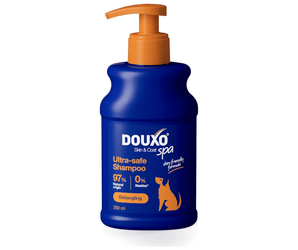 White background with a blue bottle of Douxo Ultra-safe Detangling Shampoo with orange pump.