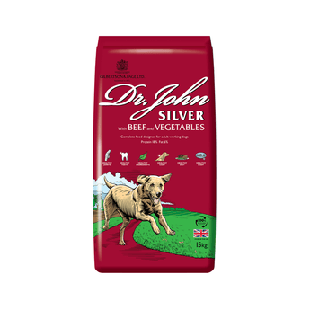 White background with a red bag of Dr.John Silver Beef and Vegetables dry food. Pictured on the bag is an illustrated Labrador dog in a farm field.