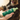 Hand holding a green pump bottle of Earth Rated No-Rinse Dog Shampoo in the foreground, with a black, tan and white dog pictured in the background.