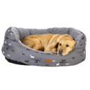 Dog lying in a gray pet bed with dog pattern on a white background