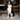 Black and white collie dog sitting on a grey Henry Wag microfibre noodle pet mat in a living room setting.