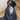 Young black and white springer Spaniel wrapped in a grey Henry Wag Pet Cleaning Towel in a bathroom setting.