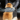 Pomeranian sat outside a car with the door open, dog has it's back to the camera with a person drying the dog with a Henry Wag grey pet glove towel.