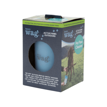 White background with a box for a Henry Wag pet paw cleaner, pictured on the box is a red setter out in a field with its paw being cleaned using the paw cleaner. Circular cut out shows the blue paw cleaner inside.