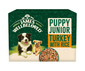 White background with a box of James Wellbeloved Turkey with Rice Puppy Wet Food. The box is green and cream with 2 puppies pictured on the box.