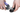 White background with a pair of hands using a BUSTER Nail Clipper on a black dog's foot.