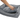 White background with a hand lifting the corner of the cushion off a bolster-type grey dog bed to show the underside.