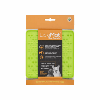 White background with a green LickiMat Mini Buddy slow feeder mat with a criss-cross surface. The Playdate mat is in black and orange packaging cardboard packaging.