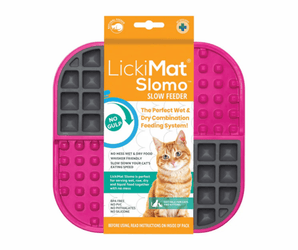 White background with a pink and grey square LickiMat Slomo slow feeder mat with a waffle and bobbly surface. The Slomo mat is in orange and white cardboard packaging with a cat pictured on the packet.