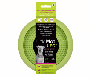 White background with a green LickiMat UFO slow feeder bowl with a bobbly internal surface. The UFO bowl is in black cardboard packaging.