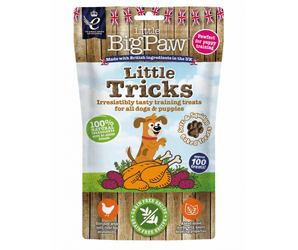 White background with a packet of Little BigPaw 'Little Tricks' dog treats. Pictured on the packet is an illustration of a brown dog with a cooked chicken and vegetables in the foreground. Text on the bag says 'Irresistibly tasty training treats for all dogs & puppies, 100% natural ingredients, soft & squidgy baked treats. Approx. 100 treats!'