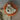 Close up of pale yellow lion shaped dog toy with long arms and legs, an orange mane and stitched detail eyes, brown nose. Pictured on a laminate floor.