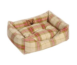 Bolster red and green checked dog bed pictured on a white background.
