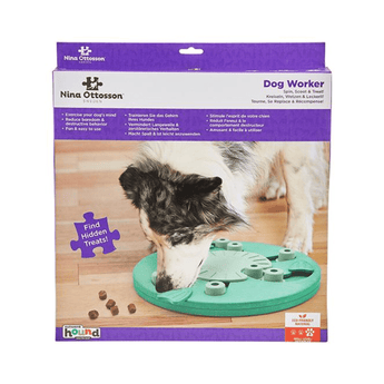 Nina Ottosson Dog Worker puzzle toy in its retail packaging, featuring a green interactive treat-dispensing board with pale green rings and a photo of a dog using the toy.
