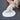 Dog paw pressing into a white foam pad on a dark surface