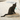 Black kitten sat on heart shaped corrugated cardboard scratcher with multicoloured star details around the outside, on a laminate floor.
