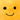 Close up of orange fruit plush toy with green leaf detail and a smiley face.