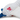 Close up of back view of seagull dog toy with a white body, grey and blue wings and tail with red stitch detail of text 'PF' on it's side. Sat on a white background.