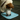 Tri-coloured mix breed dog licking blue silicone lick mat with two different textures, one with hexagon shapes, the other with small close together ridges pictured on a tiled floor.