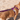Brown dog wearing a Red Dingo harness with a Red Dingo Purple Classic lead attached, on a sandy beach.