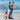 A medium sized dog wearing a Red Dingo Padded Turquoise Dog Harness on a sunny beach near the ocean