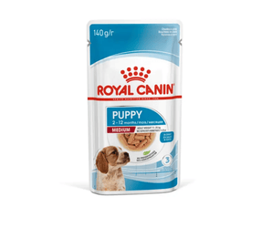 White background with a sachet of Royal Canin Medium Puppy in gravy. Pictured on the packet is a puppy, text on the tin states '2 -12 months'.
