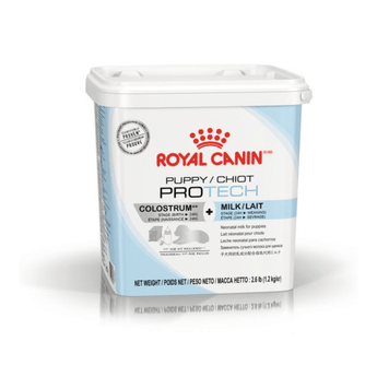 White background with a blue and white tub of Royal Canin Puppy Pro Tech Milk Replacement. Tub stats 'Colostrum + Milk. Stage (Birth > 24H)'. Pictured on the tub is a grey silhouette of a puppy, a milk bottle and packets.