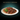 A plate of Sheba Cuisine wet cat food in gravy with a green leaf garnish, presented on a dark gradient background with the text 'TASTE WITHOUT COMPROMISE' at the top.