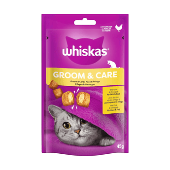 White background with a purple packet of Whiskas Groom & Care Treats, on the packet is silver tabby cat's face under a purple blanket. Text on the pack reads 'Whiskas Groom & Care, with Zinc & Omega-6 for Skin & Coat.'