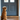 Dog waiting by doorway on wooden floor during day time