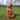 A light brown poodle cross breed dog with an Ancol Orangutan dog toy sat in front of it, pictured on grass.