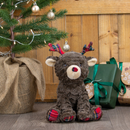 Christmas tree and presents with a brown reindeer plush dog toy with tartan features: antlers, nose and feet with stitched eye details and a cream muzzle and inner ear. 
