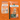 Two Arden Grange dog food packages on an orange background, demonstrating the recent change in packaging.