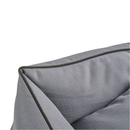 Close up of corner of a grey dog bed with black trimming. 