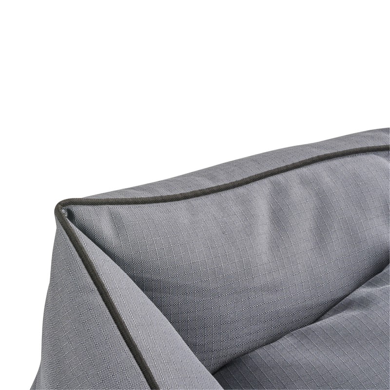 Close up of corner of a grey dog bed with black trimming. 