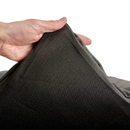 White background with a hand lifting the corner of a bolster-type black dog bed to show the underside. 