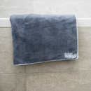 Bath tub with a Henry Wag Pet Cleaning Towel hanging over the tiled edge. 