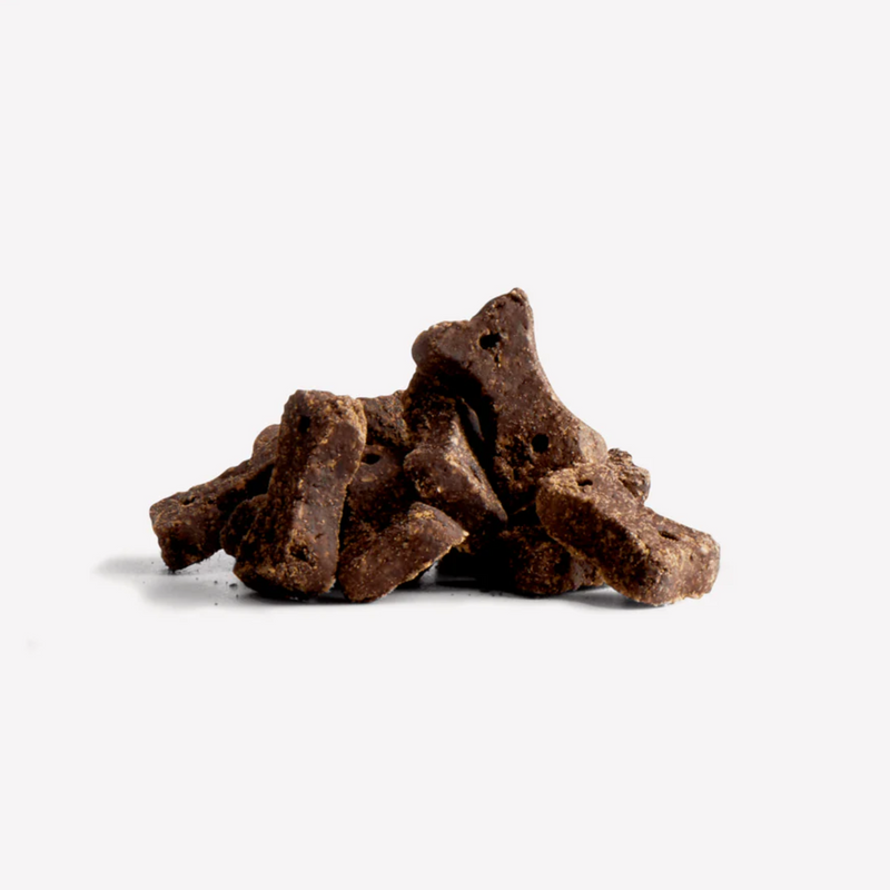 White background with a pile of bone shaped dog treats. 