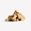 White background with a pile of bone shaped dog treats. 