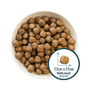 White background with a white bowl of dry dog food and a circle with a close up picture of a single kibble with the size displayed beneath '1.1cm x 1.1cm, width/depth, average size'. 