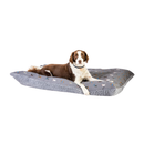 Brown and white Collie Cross lying on a pillow-type grey dog bed with illustrated dogs and a grey fleece underside pictured on a white background. 